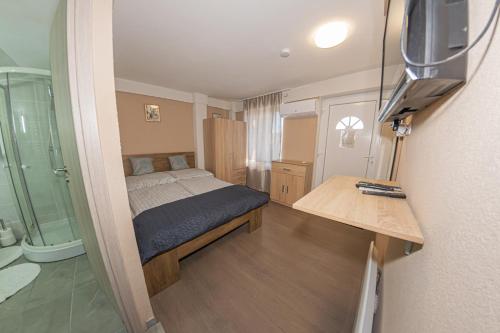 a small bedroom with a bed and a shower at Matrakapuvendeghaz in Mátraszőlős