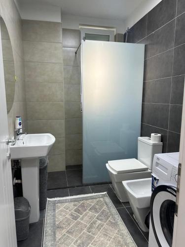 a bathroom with a white toilet and a sink at Tale Sunset Apartment in Lezhë