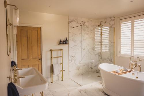 a bathroom with a tub and a sink and a shower at Luxury House sleeps 14 with Secret Bar near Bath in Warminster