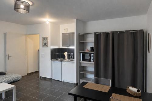 een keuken met een zwarte koelkast in een kamer bij Le Dijonnel in Dijon