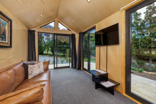a living room with a couch and a flat screen tv at Tiny on Access in Kerikeri