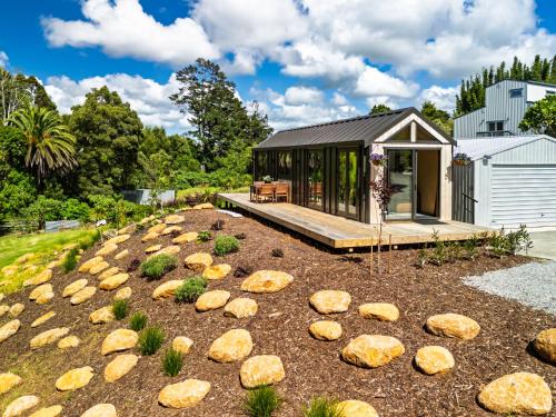 a small house with a deck and a building at Tiny on Access in Kerikeri