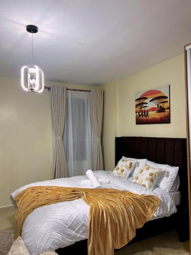 a bedroom with a bed with a blanket on it at Alyahomes in Nairobi