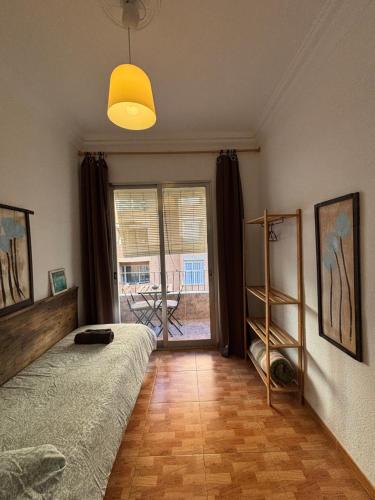 a bedroom with a bed and a large window at The Ruzafa by Laura - AVE in Valencia