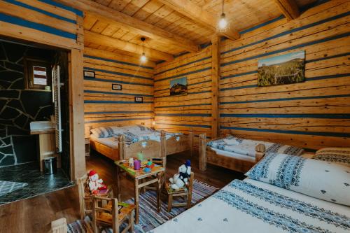 a room with two beds in a log cabin at Granddrevenica in Malá Franková