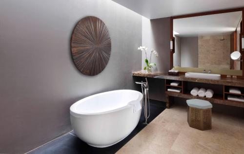 a bathroom with a toilet a sink and a bath tub at Al Baleed Resort Salalah by Anantara in Salalah