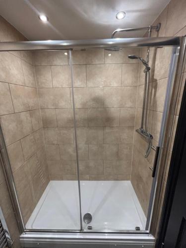 a shower with a glass enclosure in a bathroom at Airport Tavern Accommodation in Felton
