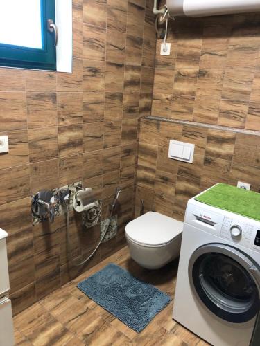 a bathroom with a toilet and a washing machine at Budha house in Lošonec