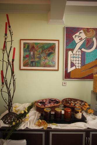a table with two pizzas and a painting on the wall at Hotel Pegasos in Nikiana
