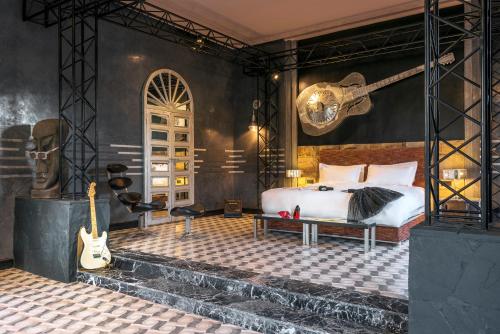 Un dormitorio con una cama y una guitarra. en The Source Hotel Music & Spa, en Marrakech