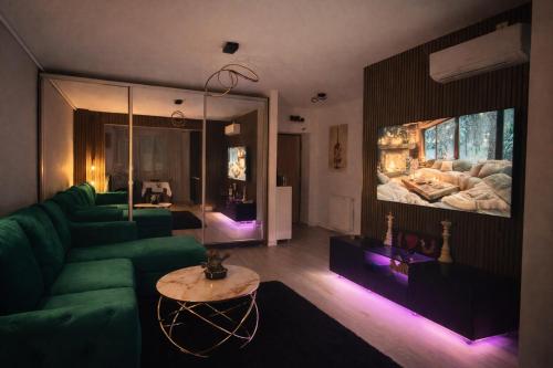 a living room with a green couch and a large aquarium at Hils Pallady in Bucharest