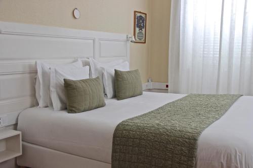 a bedroom with a large white bed with pillows at Casa Côrte Real in Porto