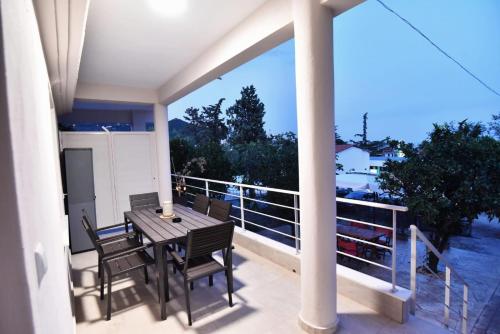 a balcony with a table and chairs on a balcony at Adams Suites in Paleo Tsifliki