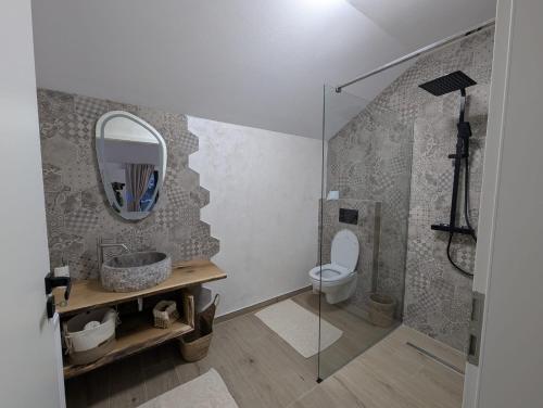 a bathroom with a toilet and a mirror at Forest House Chalet Bran in Predeluţ