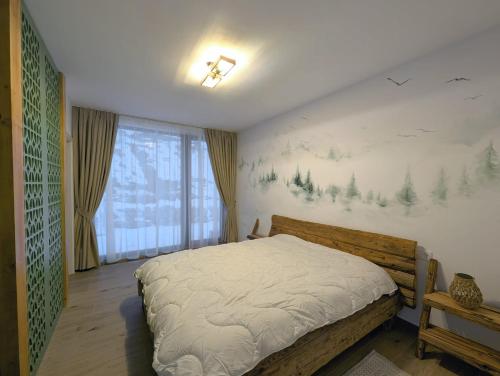 a bedroom with a bed and a painting on the wall at Forest House Chalet Bran in Predeluţ