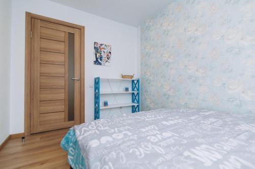 a bedroom with a bed and a wooden door at Apart Lawina in Sumy