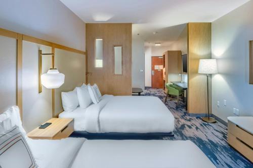 a large hotel room with two beds and a desk at Fairfield Inn & Suites Fort Worth Northeast in Hurst