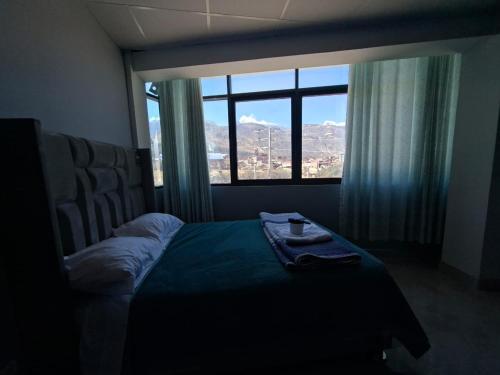 a bedroom with a bed and a large window at Mishki Punuy in Caraz