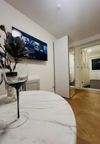 a room with a wine glass and a tv on the wall at Lakes Guest Room Annexe in Penrith