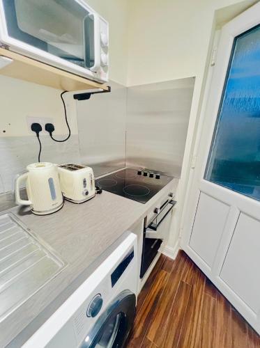 a small kitchen with two toasters on a counter at Lakes Guest Room Annexe in Penrith