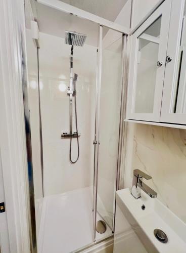 a bathroom with a shower and a sink at Lakes Guest Room Annexe in Penrith