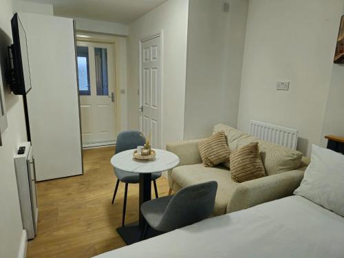 a living room with a couch and a table at Lakes Guest Room Annexe in Penrith