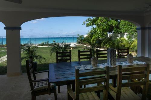 a dining table and chairs with a view of the ocean at Sandgate in Bridgetown