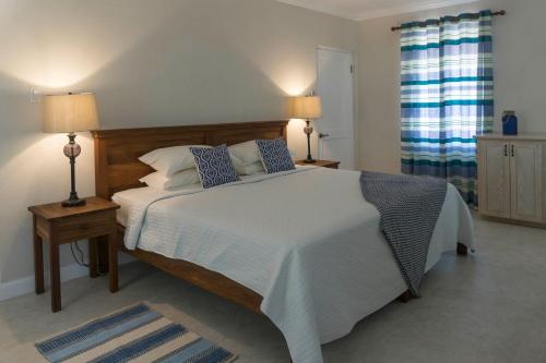 a bedroom with a large bed with two lamps and two tables at Sandgate in Bridgetown