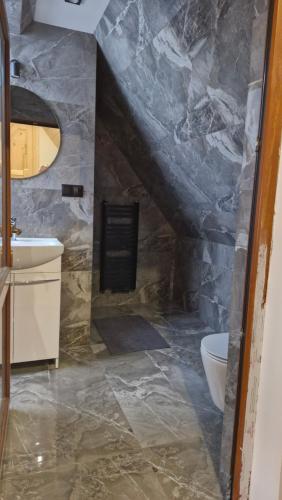 a stone bathroom with a sink and a toilet at Chochołowsko-Witowski Wypoczynek in Witów