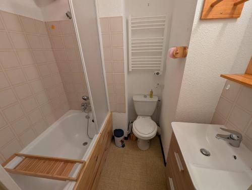 a bathroom with a toilet and a tub and a sink at Studio pied des pistes in Réallon