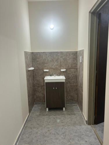 a bathroom with a sink and a tile wall at Cima Departamentos in Rivadavia