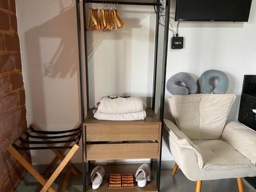 a dressing room with a chair and a mirror at Chalé Makar - Hidromassagem aquecida e vista para as montanhas in Serra do Cipo