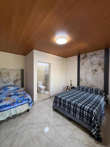 a bedroom with two beds and a bathroom at Hostal Casa Hope in Rivas