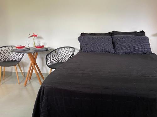 a bedroom with a bed and a table with chairs at Chalé Makar - Hidromassagem aquecida e vista para as montanhas in Serra do Cipo