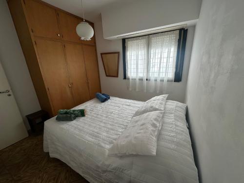 a bedroom with a white bed and a window at La casa de Chola in Playa Unión