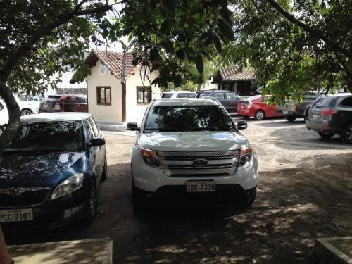 two cars parked in a parking lot in front of a house at Hotel y Hosteria Natabuela in Natabuela