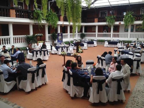 a group of people sitting at tables in a banquet hall at Hotel y Hosteria Natabuela in Natabuela
