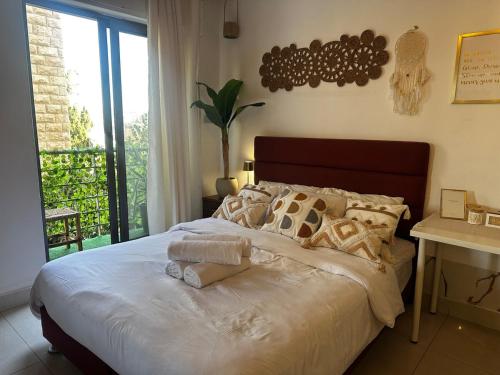a bedroom with a large bed with towels on it at Boho studio in Amman