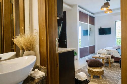 a bathroom with a tub and a sink and a bedroom at Boho studio in Amman