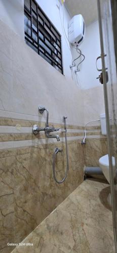a shower in a bathroom with a toilet at Lavish Abode black & white in Guwahati