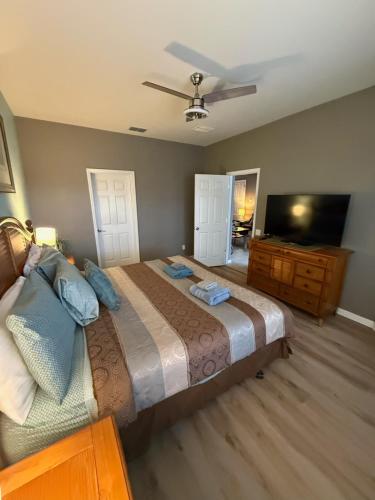 a bedroom with a bed and a flat screen tv at Windsor Hills Resort 5BR Villa, Amenities, Private Pool & Water Park, Near Disney, Sea World, Universal in Orlando