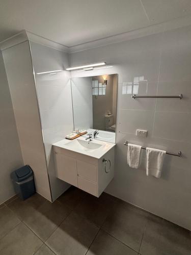 a bathroom with a sink and a mirror at Shakespeare Motel in Mackay