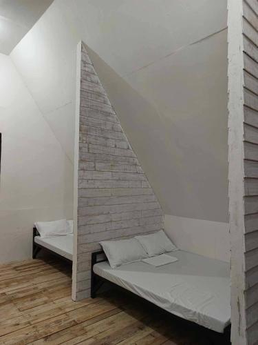 a room with two beds and a brick wall at Campo De Laiya in San Juan
