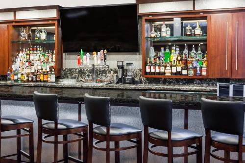 a bar with chairs and bottles of alcohol at Wyndham Garden Warsaw in Warsaw