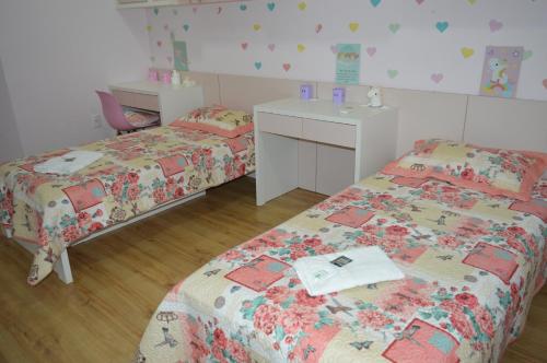 a bedroom with two beds and a desk and a sink at Casa de huéspedes Aruska in São Gabriel