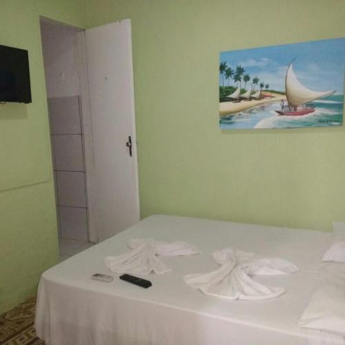 a bedroom with a bed with towels on it at Pousada Maresia in Fortaleza