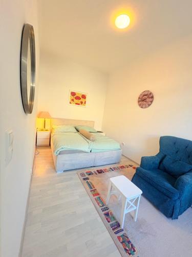 a bedroom with a bed and a blue chair at Beenie 20 in Linz