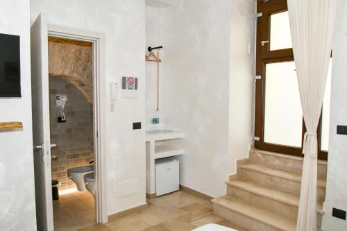 a bathroom with stairs and a sink and a window at Hasu Rental Rooms in Trani