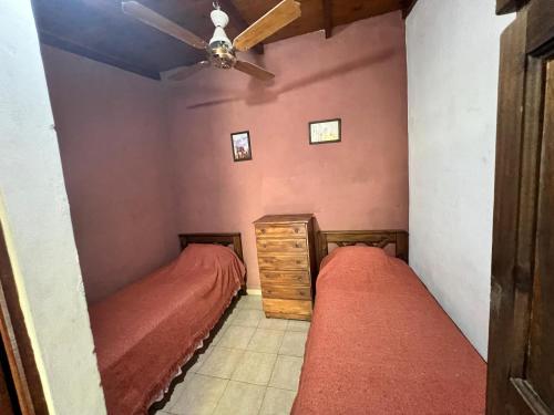 a bedroom with two beds and a ceiling fan at La Nueva Vecindad in San Bernardo