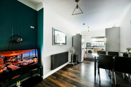 a living room with a large flat screen tv on a wall at Beautiful Modern Apartment on Wick Lane in London
